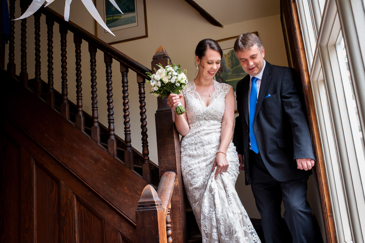 Bride and Father walk down the stairs at The Beacon House wedding venue in Kent