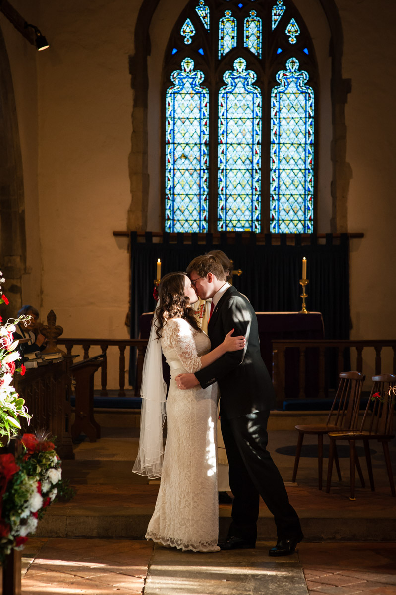 charlotte and marks first kiss after their winter church wedding in kent