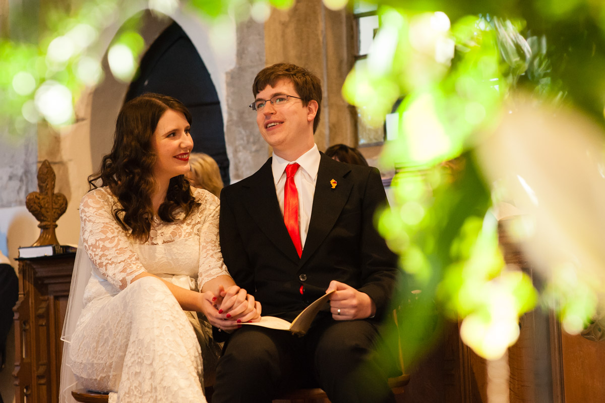 photograph of charlotte and mark listening to vicars address during their kent wedding