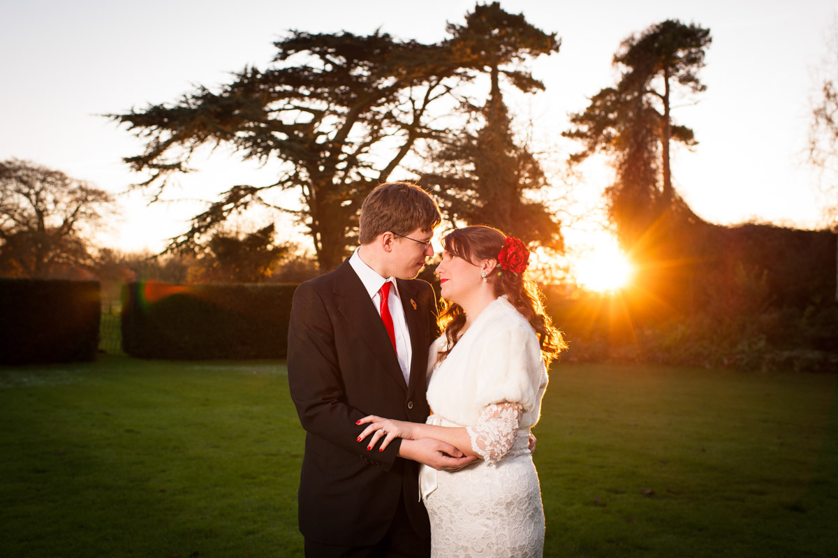 sunset photograph of charlotte and mark in garden at nursted court during their kent winter wedding reception