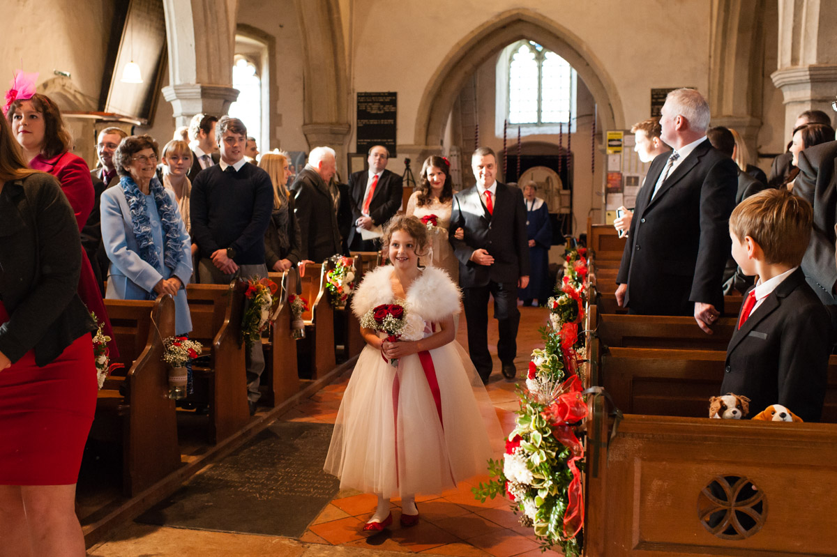 flower girl walks up church aisle followed by charlotte and her dad