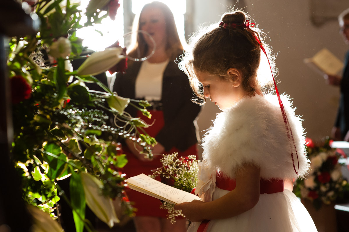 photograph of flower girl at charlotte and marks church wedding lit by sun through window