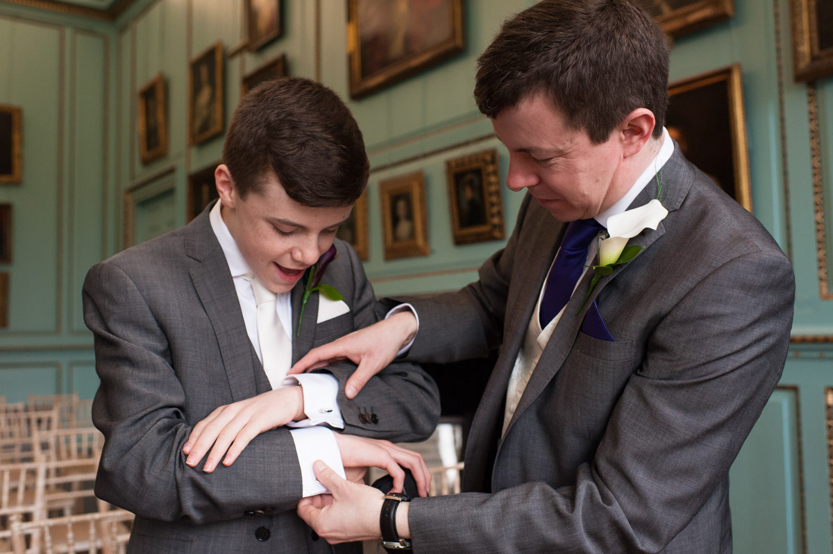 Groom and his groomsman fix cufflinks before the wedding ceremony at Bradbourne House