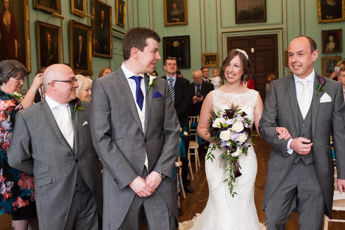The groom looks at his bride as she walks up the aisle at Bradbourne House wedding