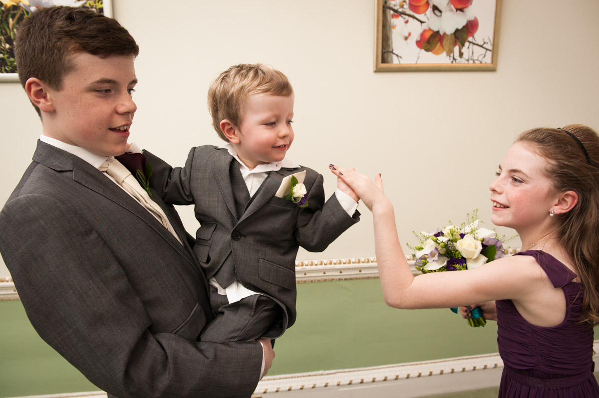 Young pageboy enjoys some fun with his sister at the wedding of his mum and dad