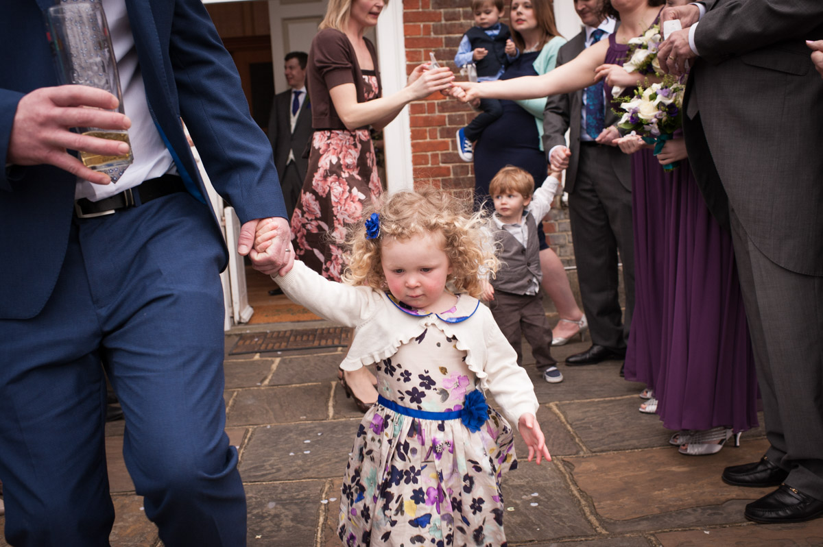 Guests at a wedding at Bradbourne House prepare for the confetti photo outside on the steps