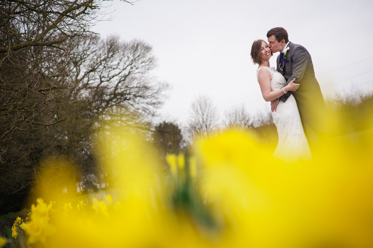 Portrait of the wedding couple at Bradsbourne House outside with daffodils in the foreground