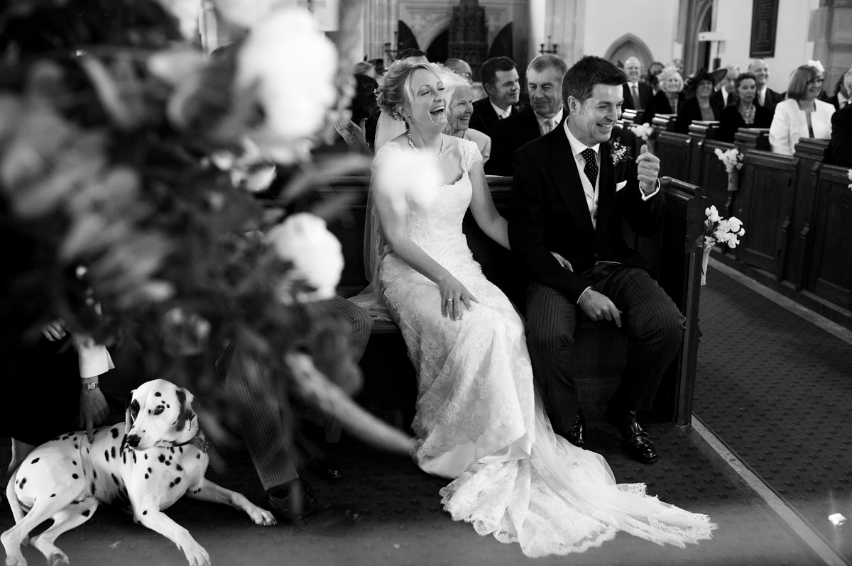 katie and Alec laugh during their Kent church wedding in Frittenden