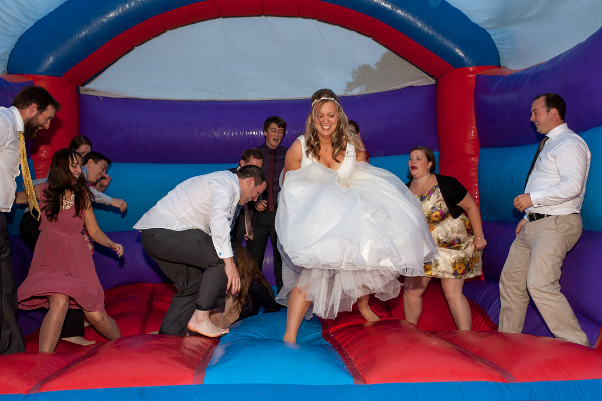 Bride and guests enjoy bouncy castle fun at Latimer Place wedding