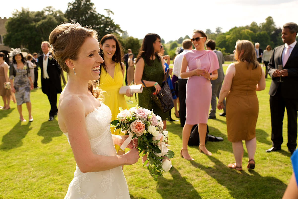 timea laughs with her wedding guests on the lawn at leeds castle in kent