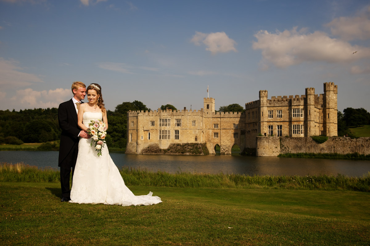 photograph of time and edmund with leeds castle in the background after their wedding there