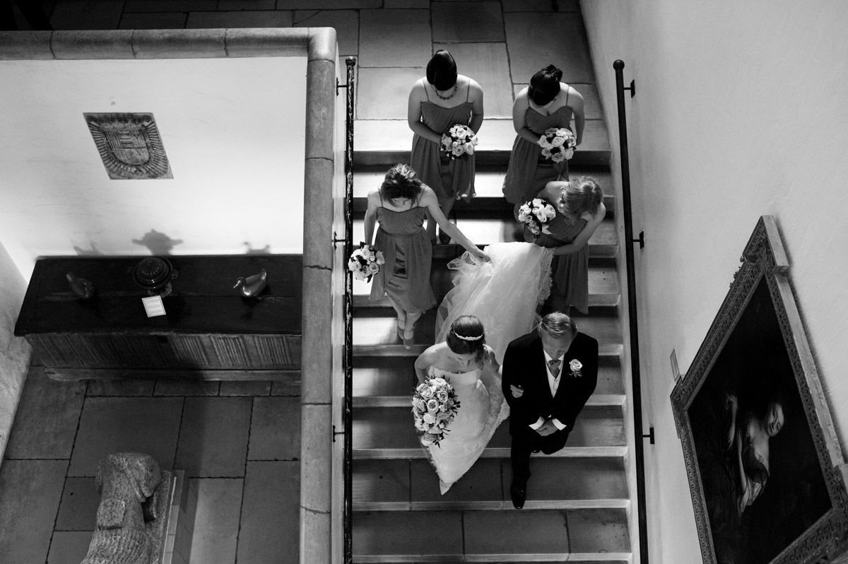 bride and bridesmaids walking down the stairs at leeds castle before wedding ceremony