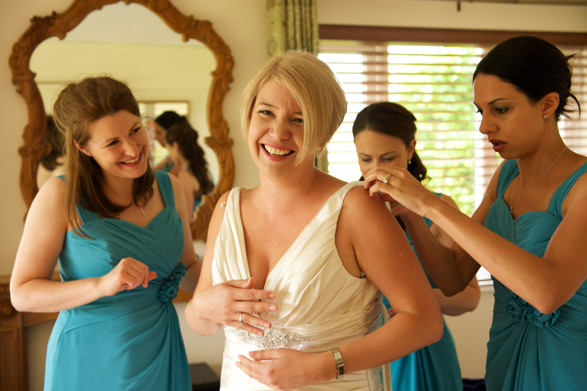 Bridesmaids help get Sarah into her wedding dress before her ceremony at Lympne Castle