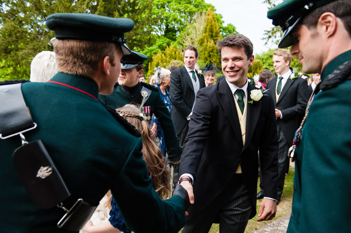 Nick shakes hands with wedding guest after his church ceremony