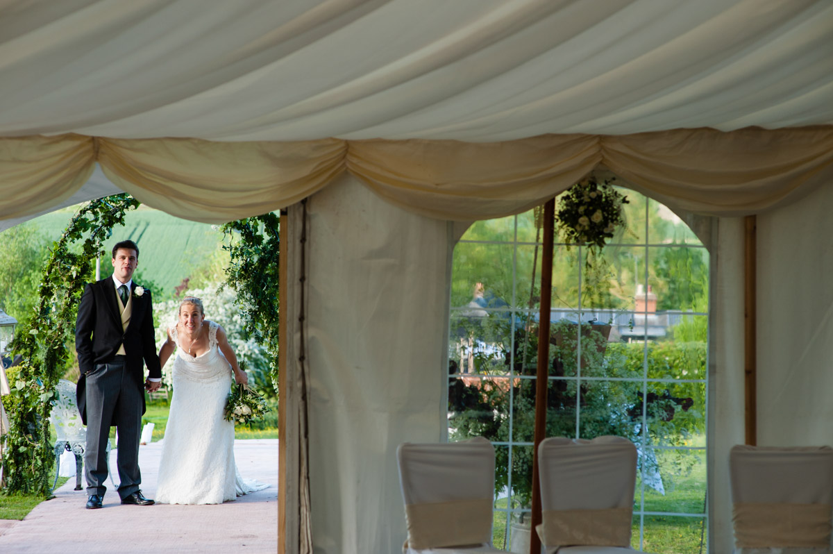 Bride and groom wait to be announced into wedding marquee at petham in Kent