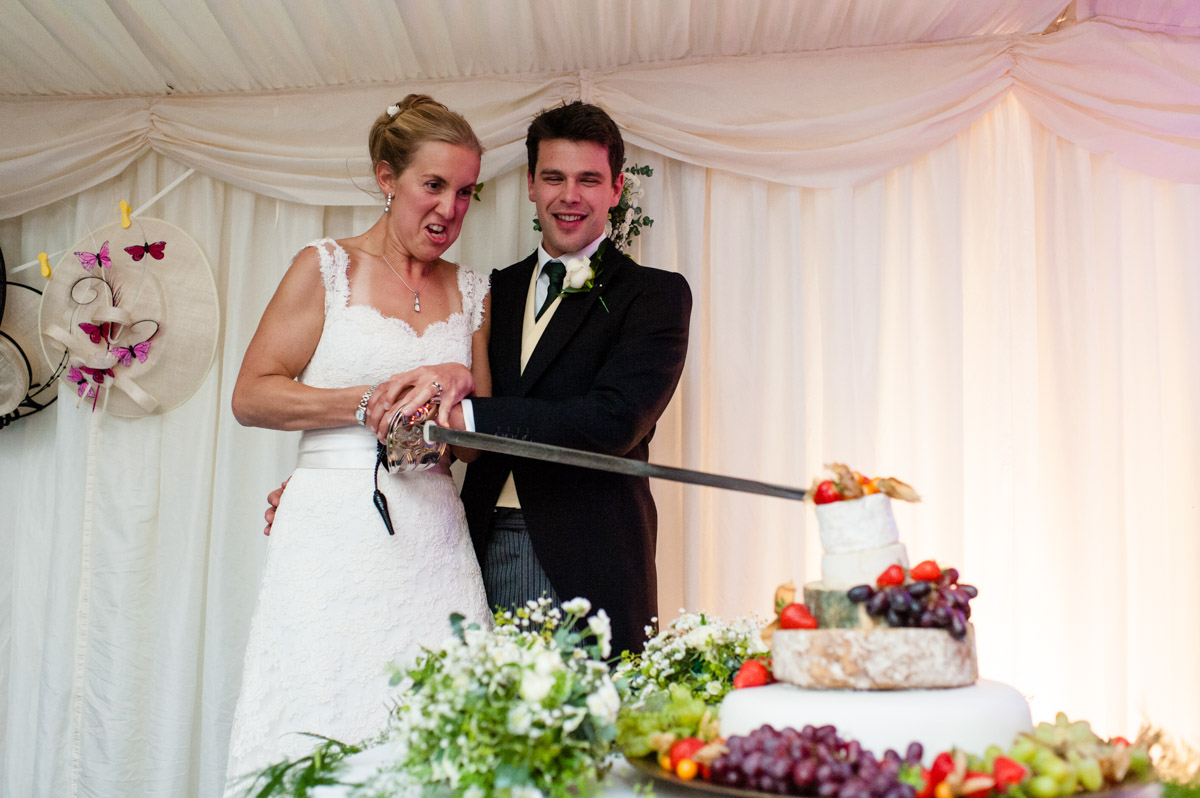 Olivia and nick cut their wedding cake with sword