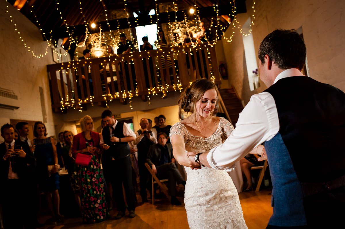 Catherine and jonny do their first dance inside Kingston Village hall in Kent which is decorated with fairy lights