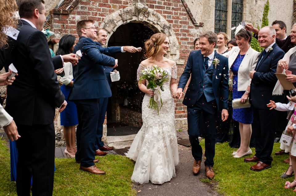 Wedding guests throw confetti over Catherine and Jonny as they leave church