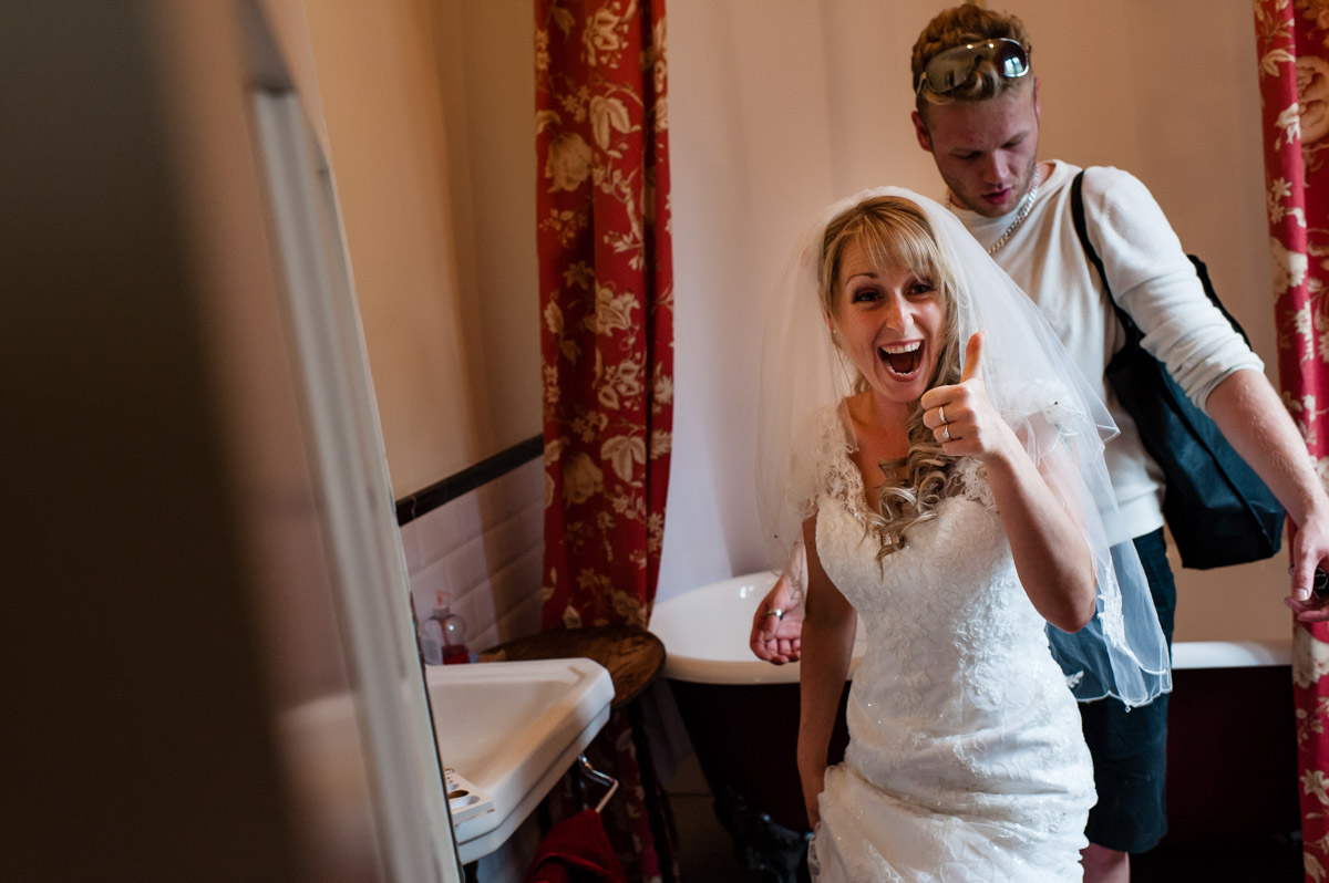 Bride gives thumbs up before her wedding ceremony at St Augustines priory in Kent