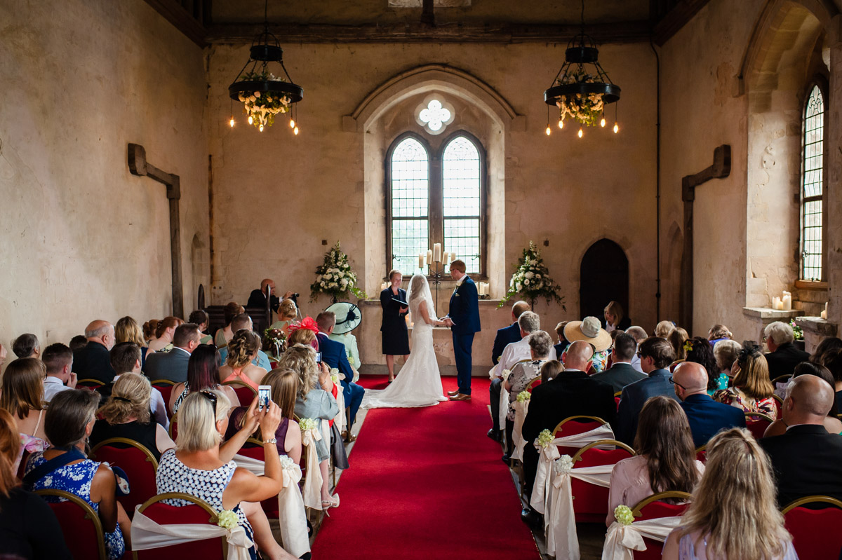 Photograph of bride and groom down the aisle inside st augustines priory ceremony venue