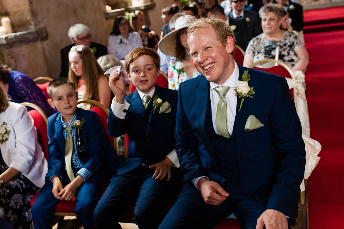 best man and page boys sitting during wedding ceremony at st augustines priory in kent