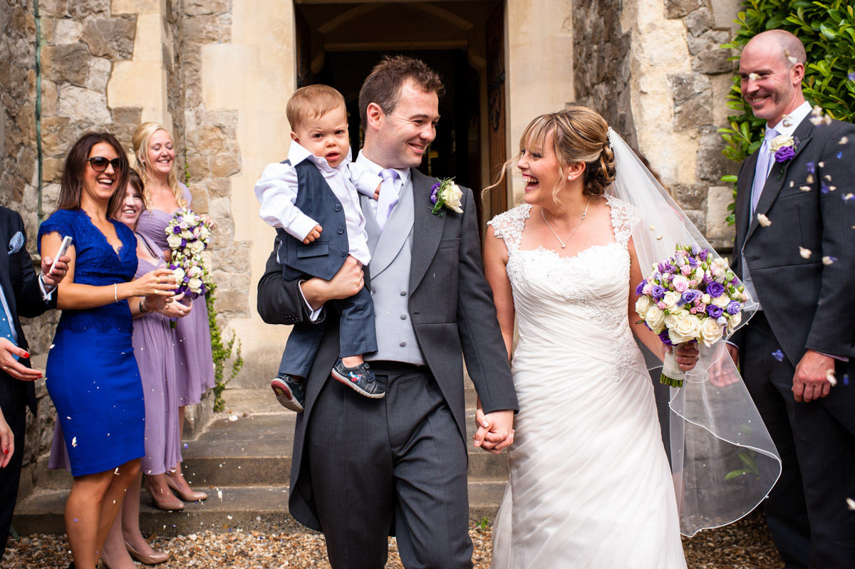 Bride and Groom receive confetti outside St Edmunds Chapel, Canterbury on their wedding day