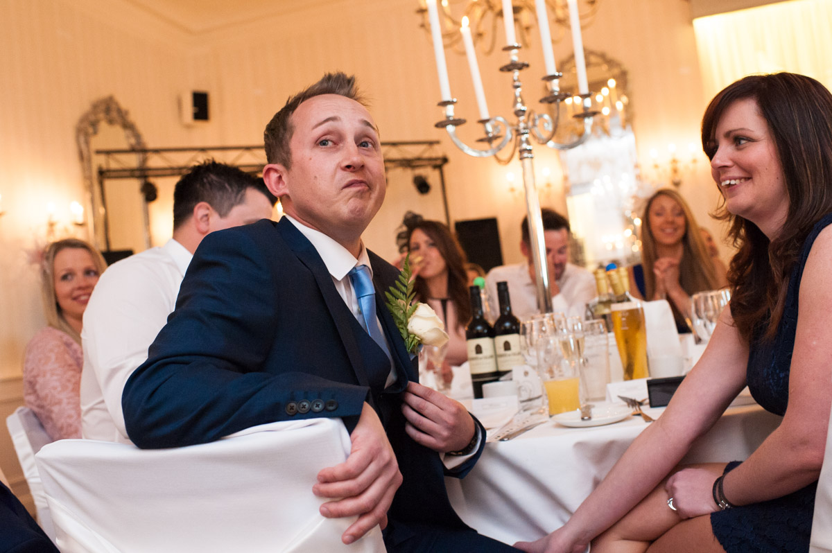 Best man pulls a face while the groom mentions him in his speech at his wedding reception in the Imperial Ballroom in Hythe Imperial Hotel