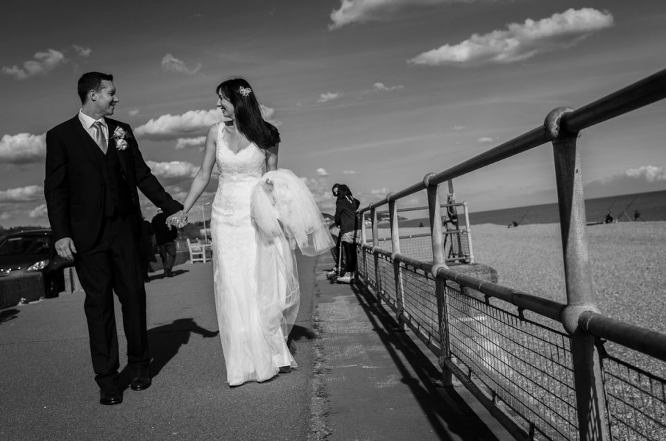 Bride and groom walk the promenade outside Hythe Imperial Hotel