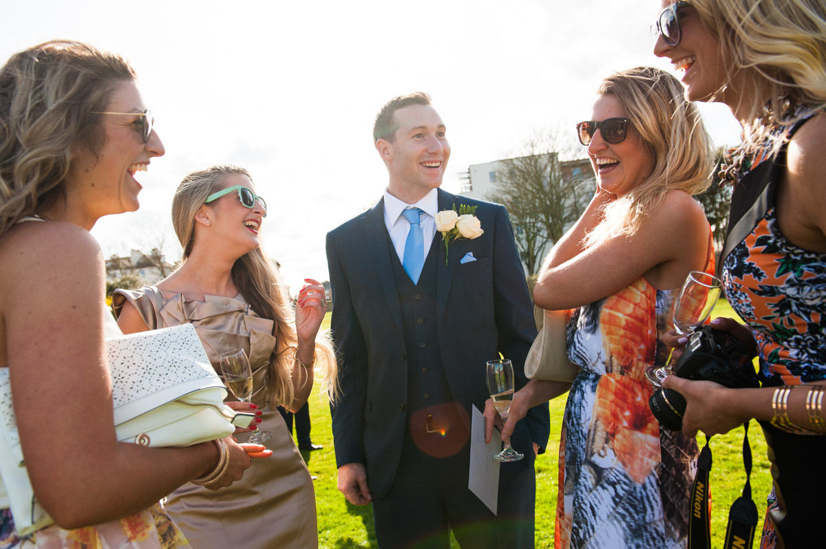 Groom and wedding guests enjoy the sun outside at the Hythe Imperial Hotel in Kent