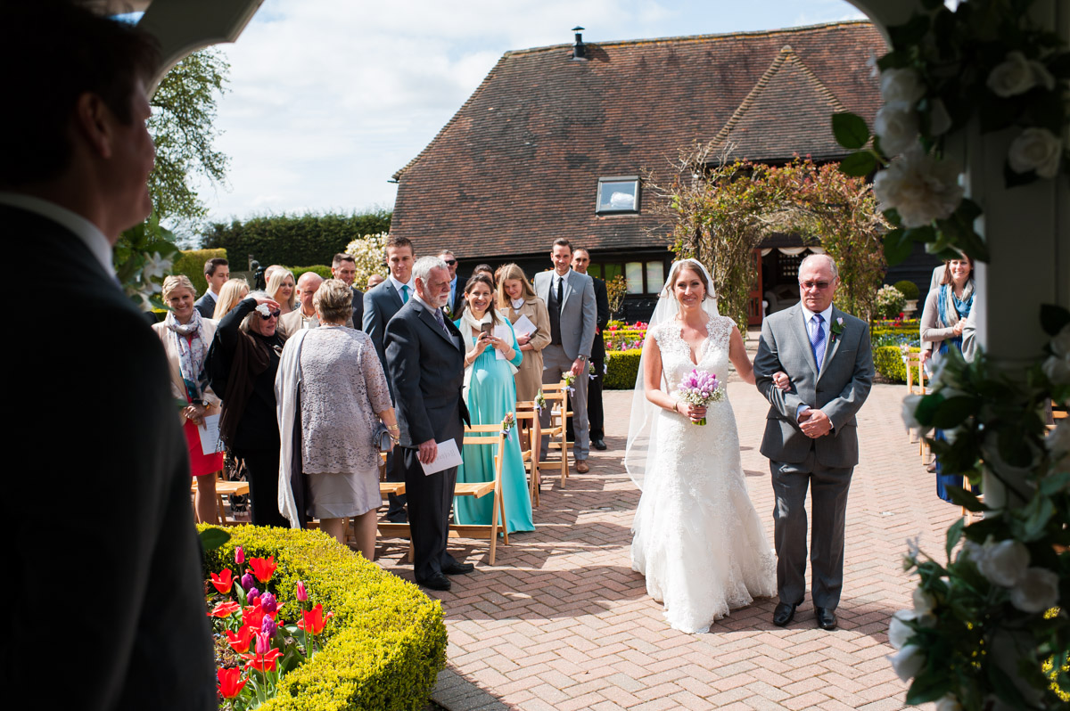 Bronwyn and her father walk up the aisle at the old Kent barn