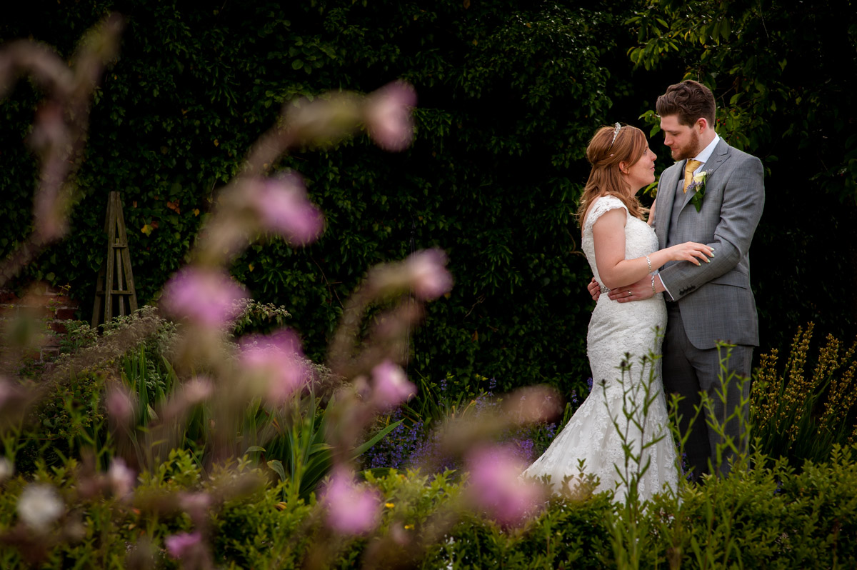 Potrait photograph of amy and darren in the garden of their wedding venue near ashford in Kent