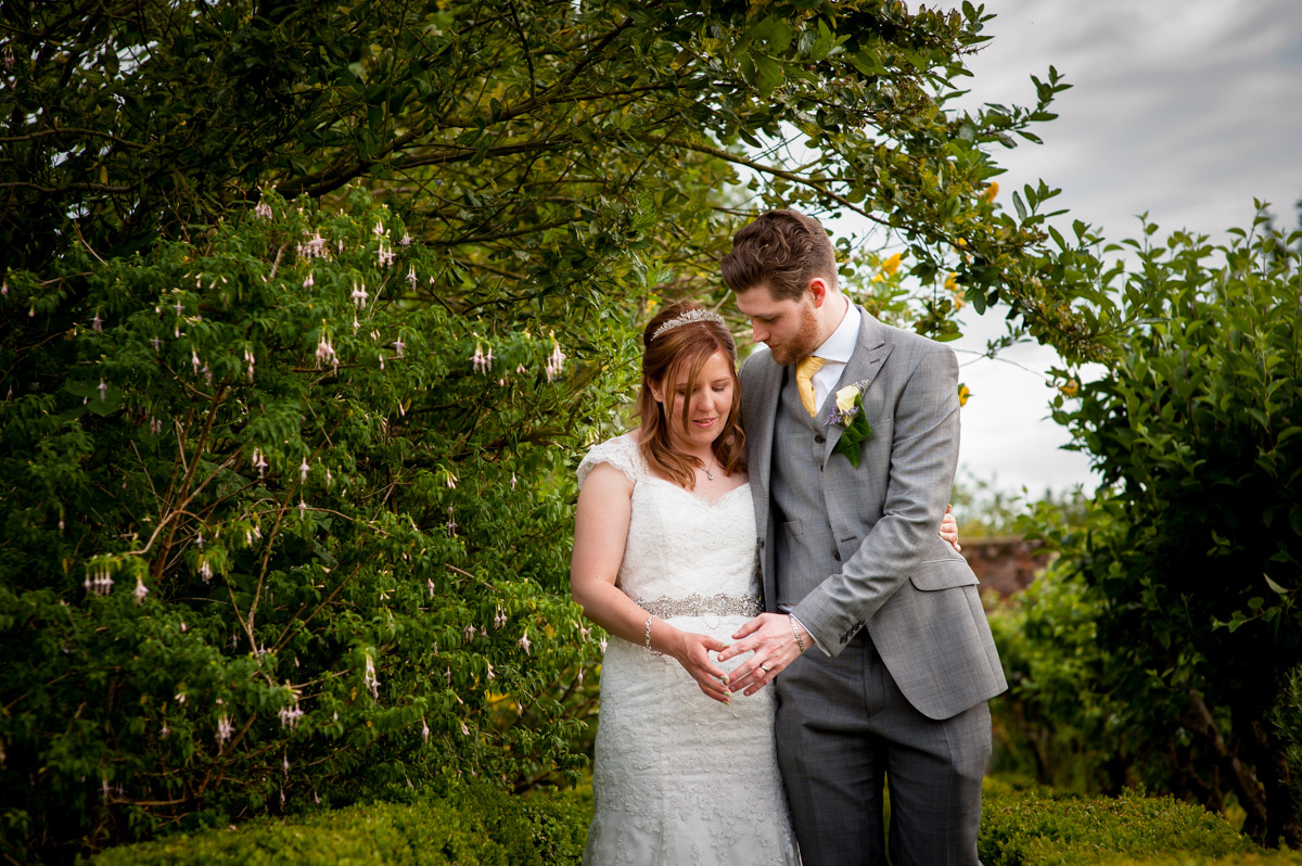 Photograph of amy and darren walking in the gardens on their wedding day