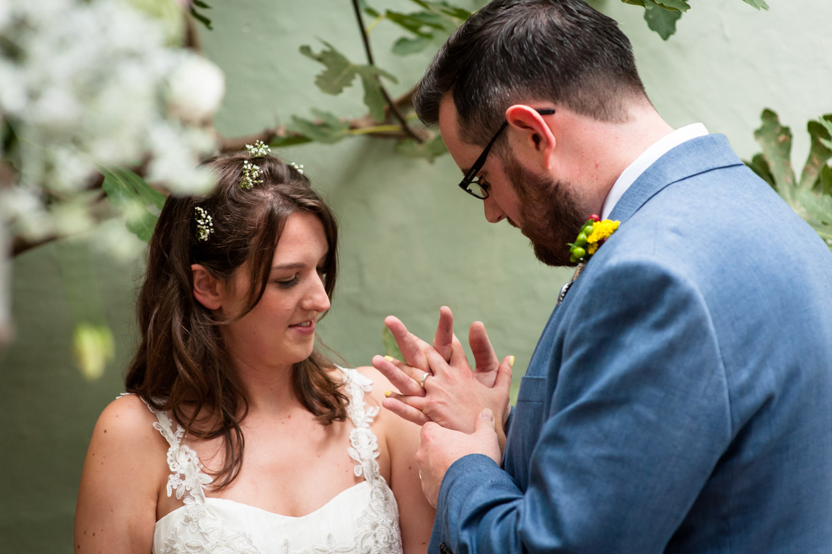 wedding couple look at their wedding rings after ceremony in kent venue, the secret garden