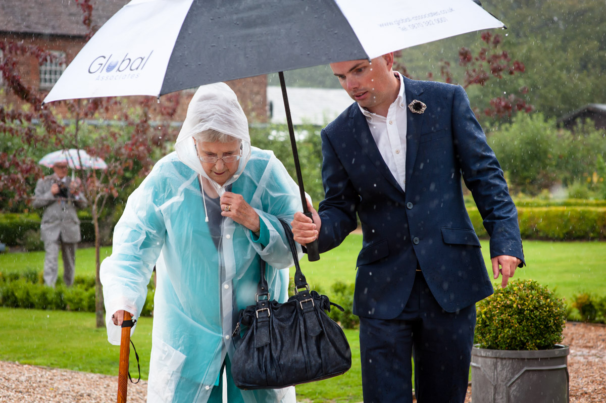 rainy day summer wedding, guests under umbrella