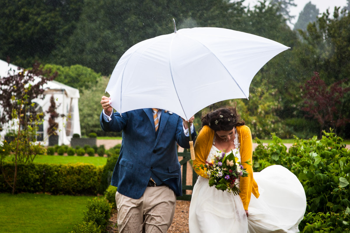 Photograph of rachel and Daniel on their wet wedding at the secret garden in kent
