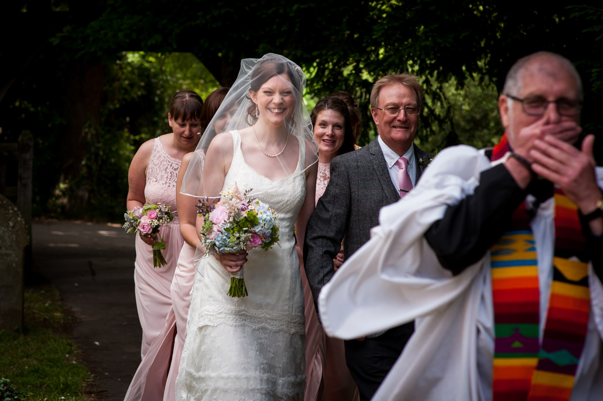 vicar photobombs photograph while gaby is walked to church for her wedding