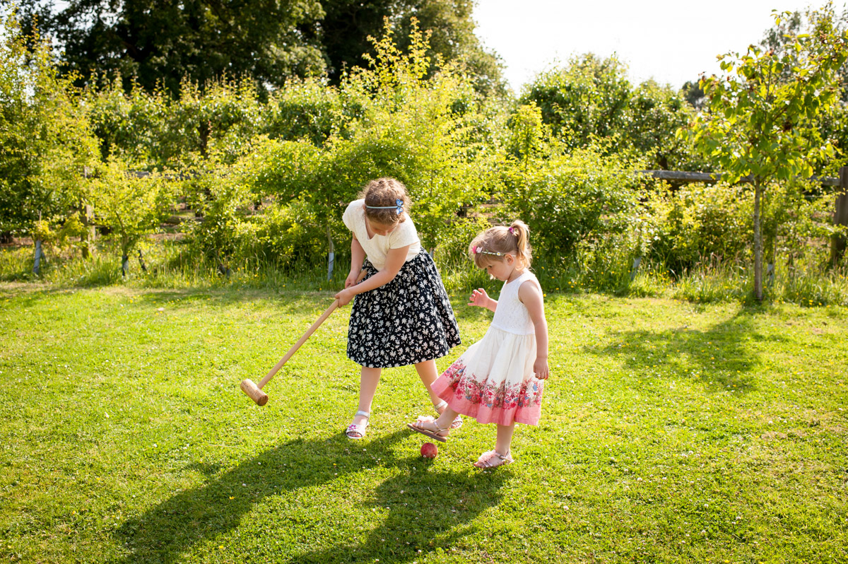 little girls play croquet at wedding reception