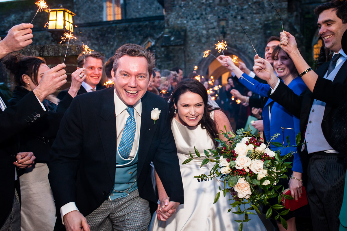 Photograph of Marcus and Frances under sparklers held aloft by wedding guests