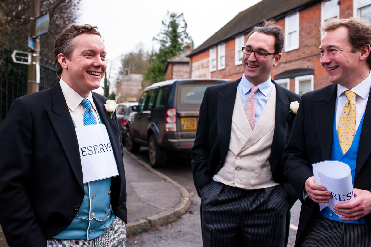 Grromsmen place a reserved sign around Marcus's neck before his Kent wedding