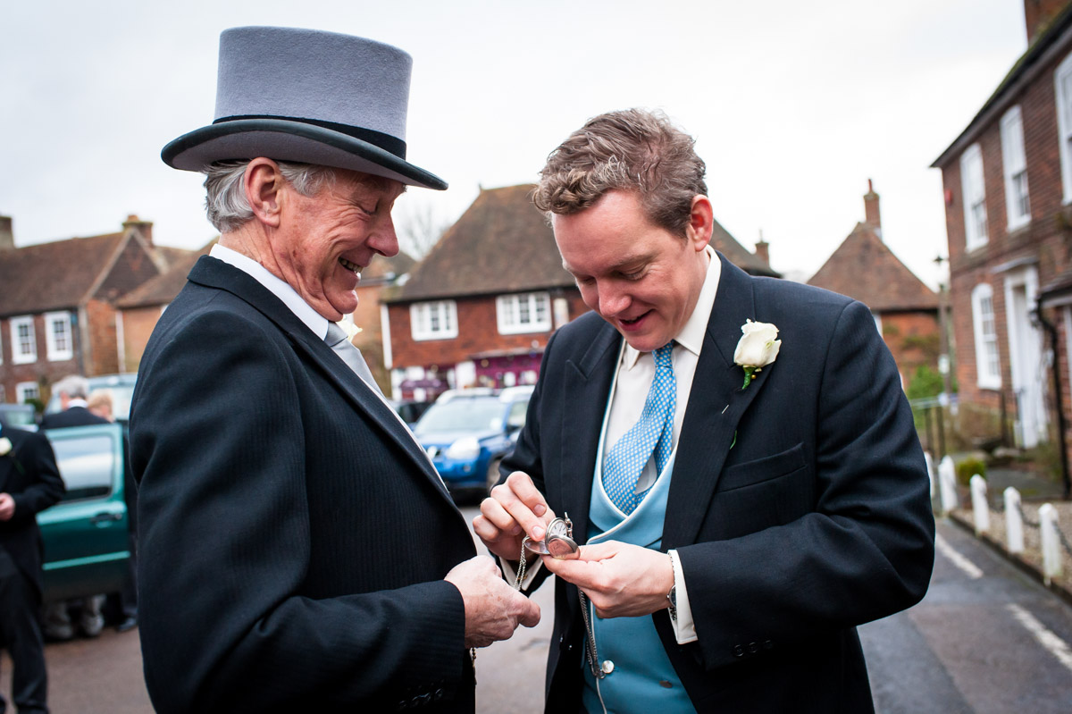 Photograph of Marcus and his father looking at pocket watch before the wedding ceremony in Elham church, Kent