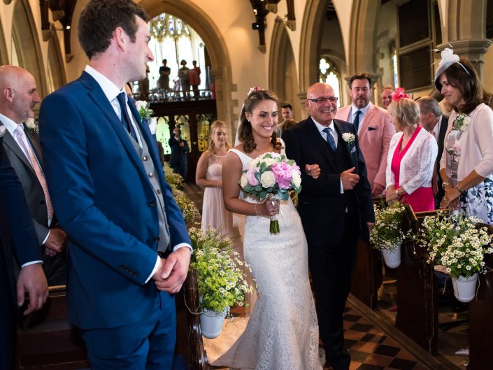 Fatehr of the bride walks his daughter up the aisle during her church wedding near Maidstone