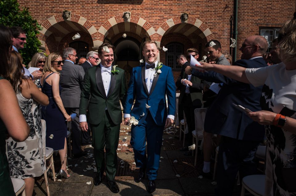 david and Simon are photographed walking down the aisle after their outdoor wedding ceremony at Port Lympne in Kent
