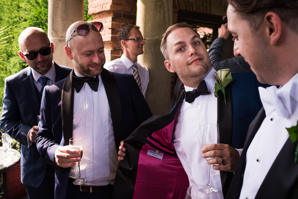 Simon is photographed enjoying time with his wedding guests during the drinks reception at his Kent wedding
