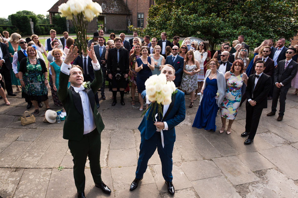 David and Simon are photographed throwing their bouquets at their Kent wedding