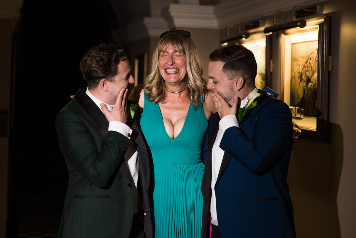 David and Simon laughing with their wedding guest at Port Lympne Mansions in Kent