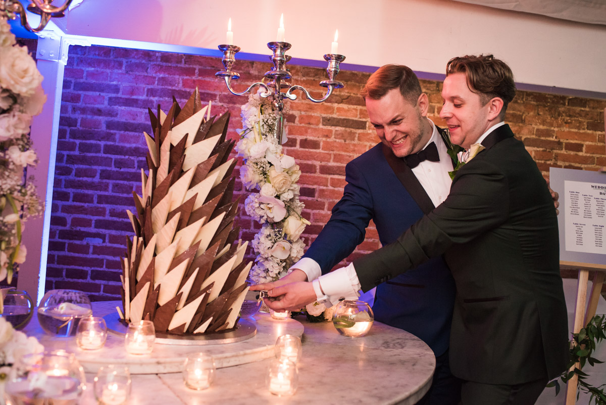 david and simon photographed at their wedding at Port Lympne in Kent cutting the cake