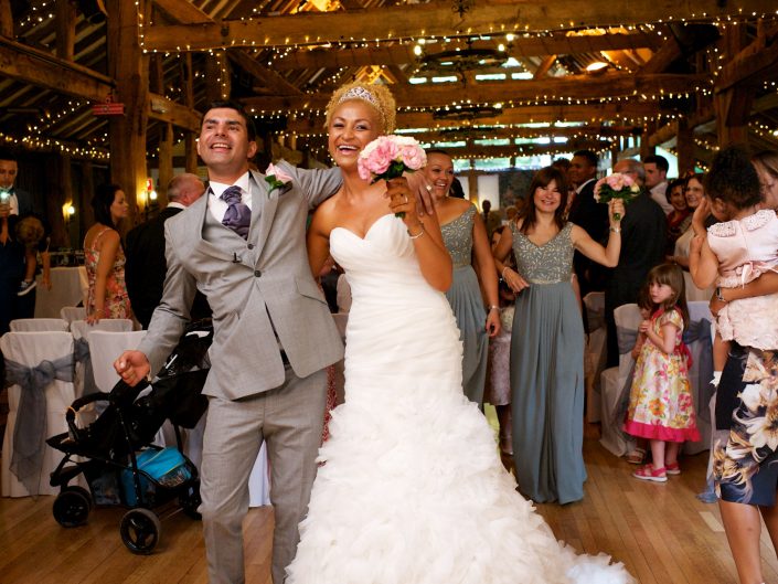 Judy and Rick are photographed celebrating their walk down the aisle after their wedding ceremony at High Rocks in Tunbridge Wells in Kent