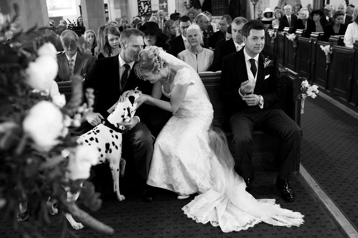 Black and white photograph of Kate, Alec and their dog Basil during their Kent church wedding