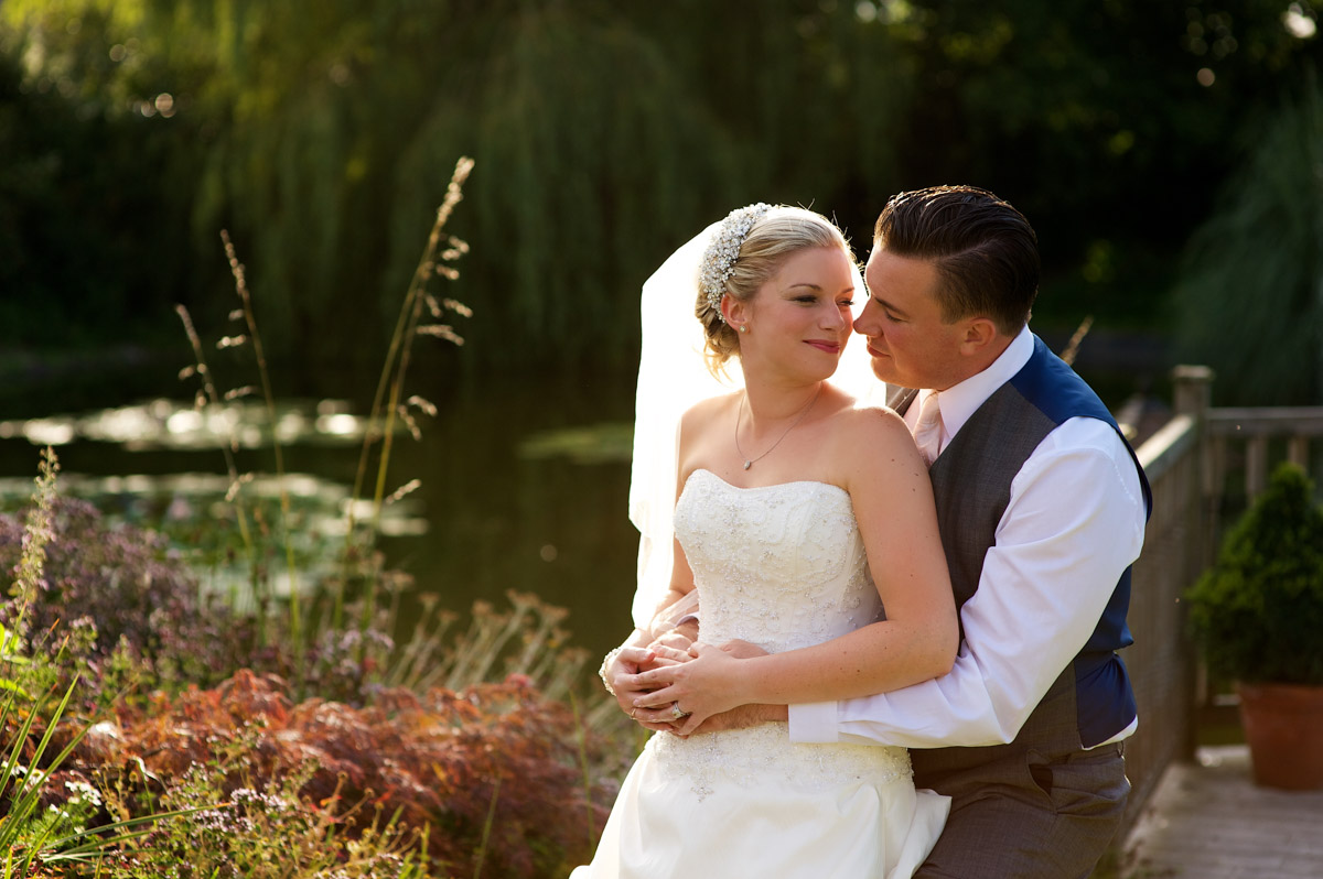 Photograph of Emma and Nick after their wedding ceremony by the pond at The Old Kent barn in Kent