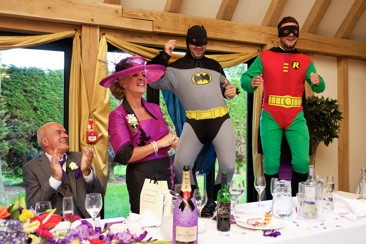 The two best men at Emma and Nicks wedding at The Old Kent Barn are photographed dressed in batman and Robin suits